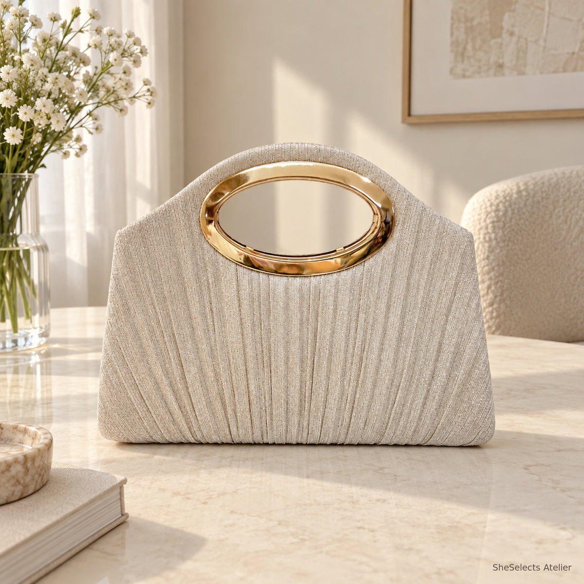Champagne pleated shell handbag with oval metal handle, front view