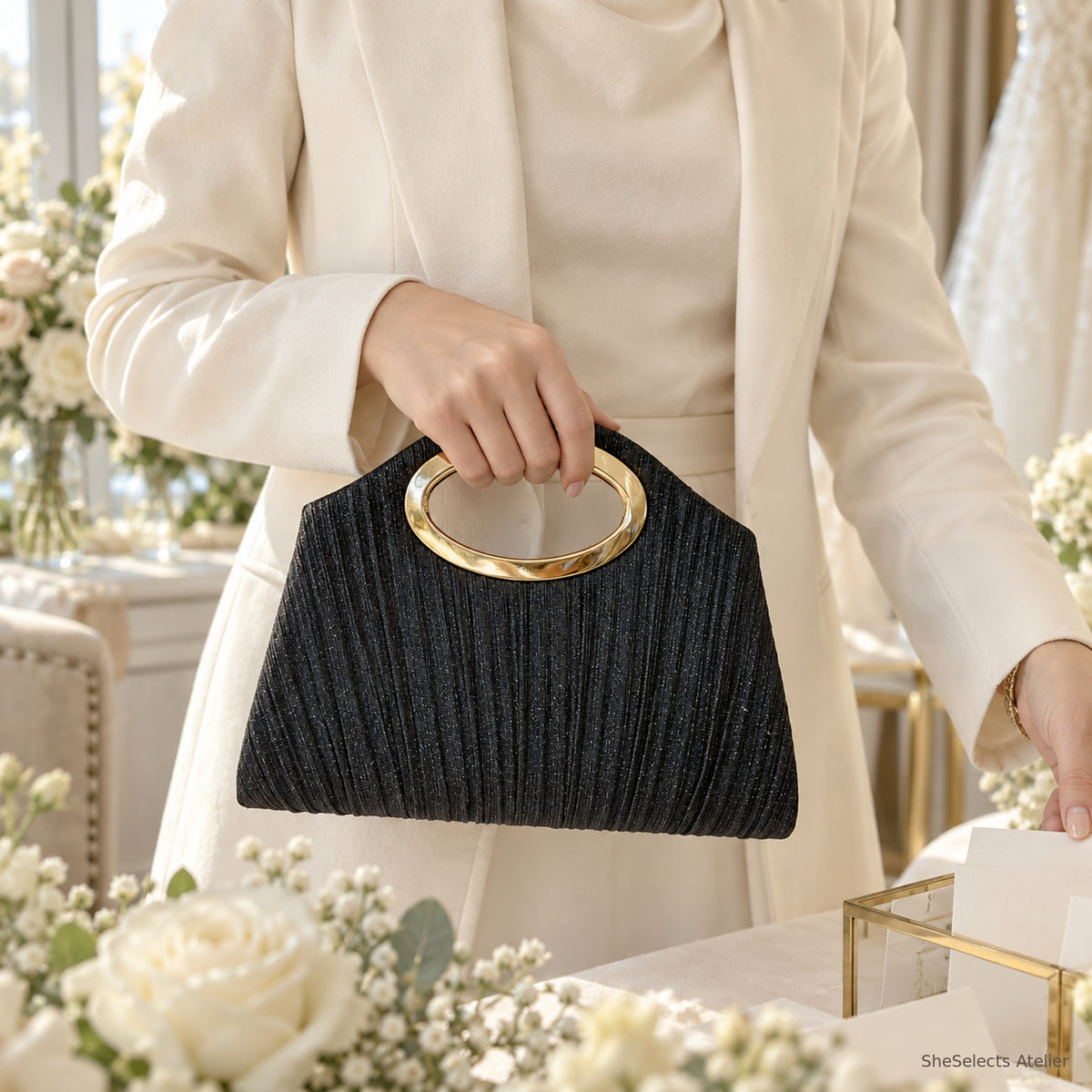 Black pleated handbag styled for a wedding guest