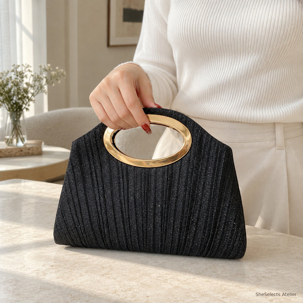 Black pleated handbag held through its oval handle