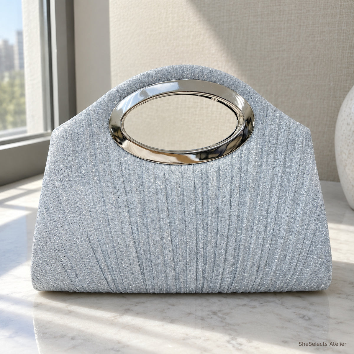 Close view of the silver pleated fabric and oval metal handle