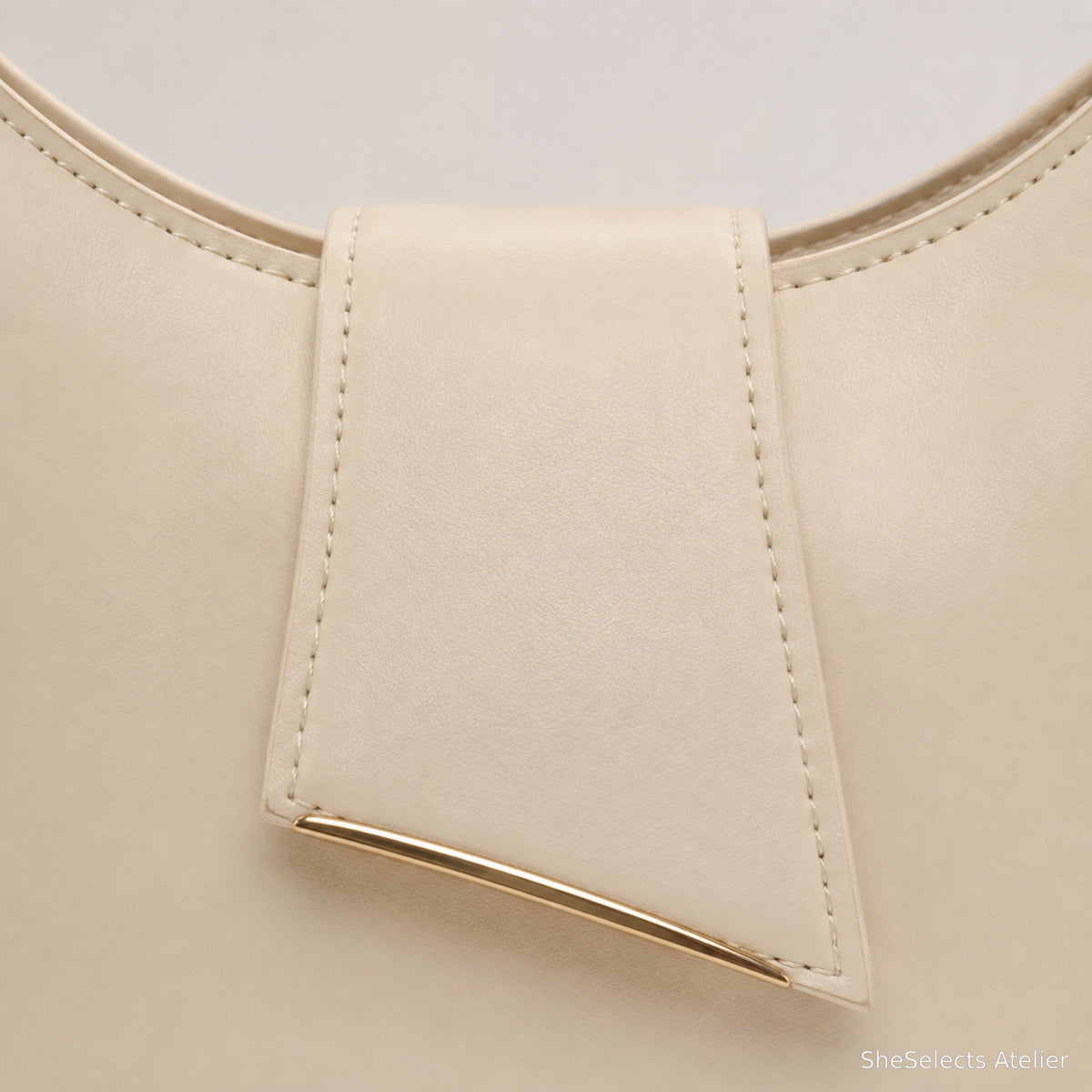 Folded front pocket and gold tone bar close up