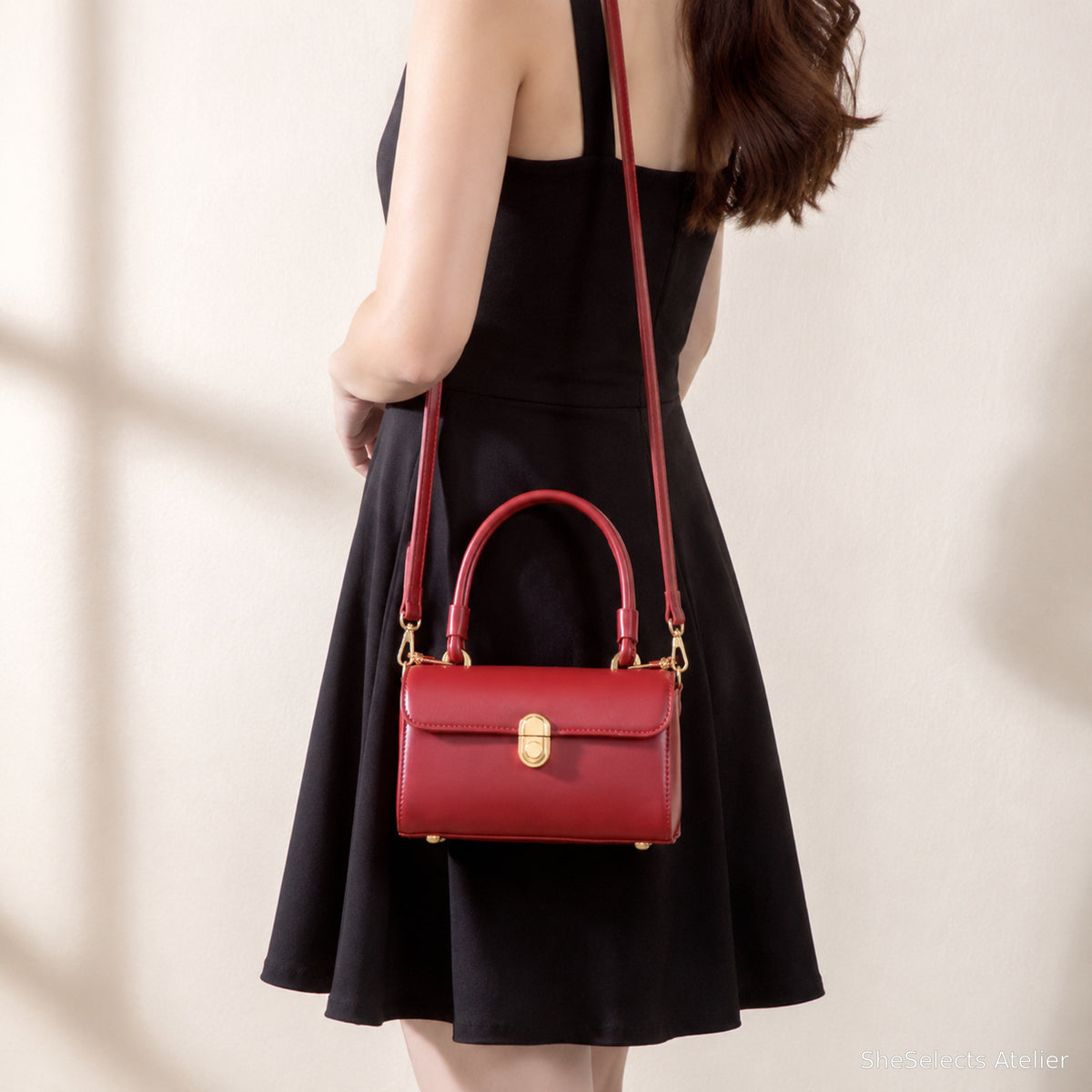 Red shoulder bag styled with a black dress