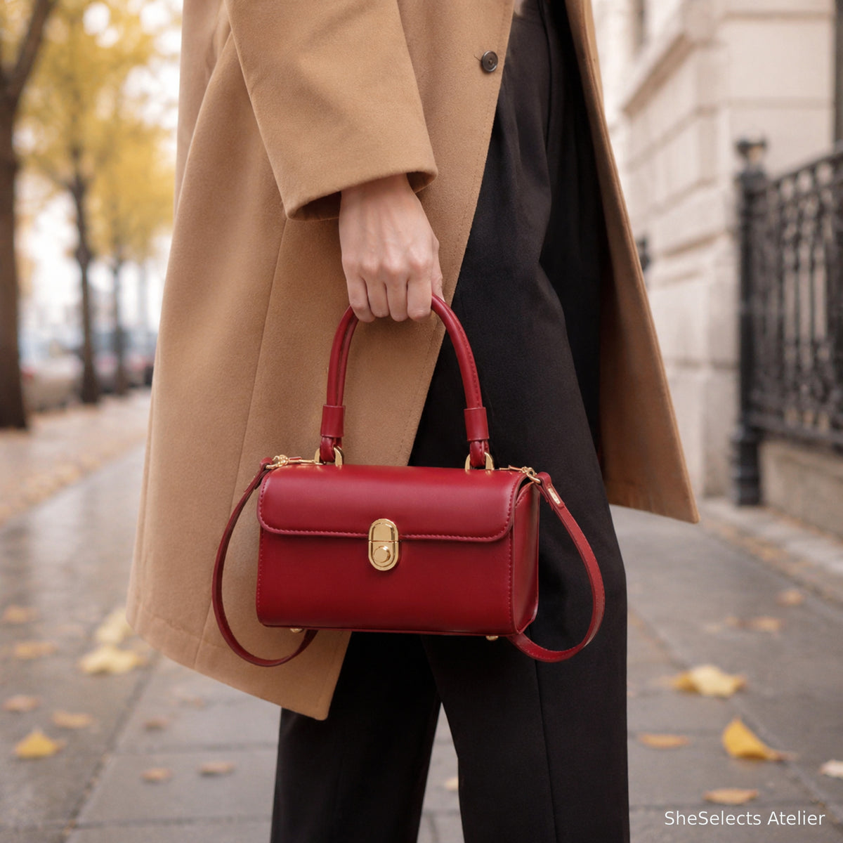 Red top handle handbag styled for fall with camel coat