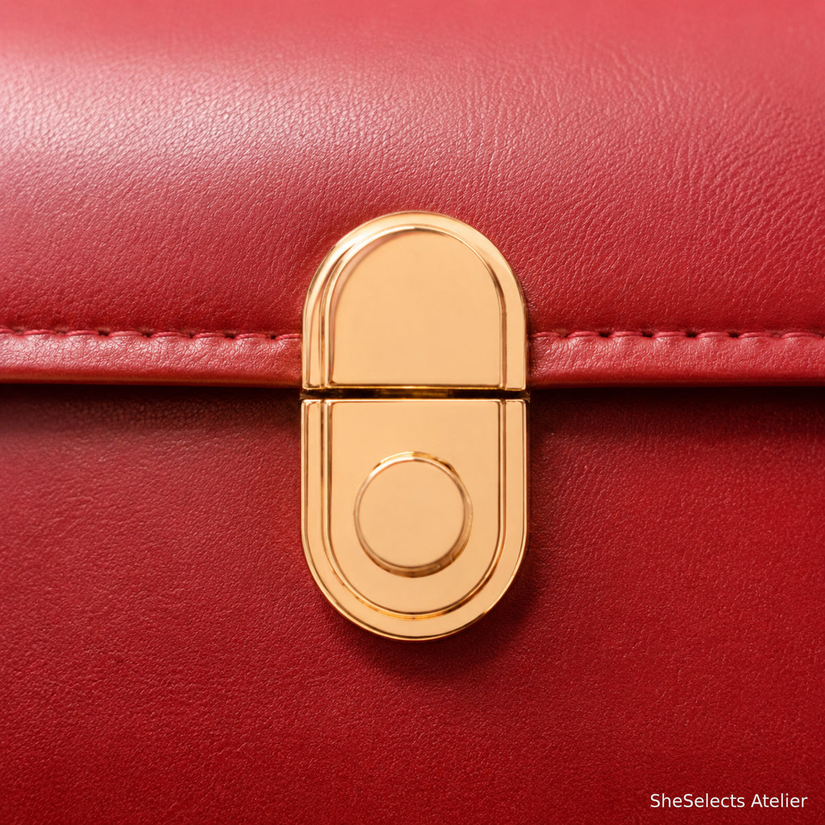 Gold-tone clasp close-up on red shoulder bag